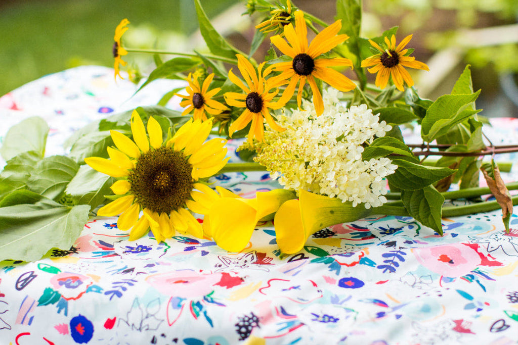 Yellow sunflowers and white flowers on a colorful mat