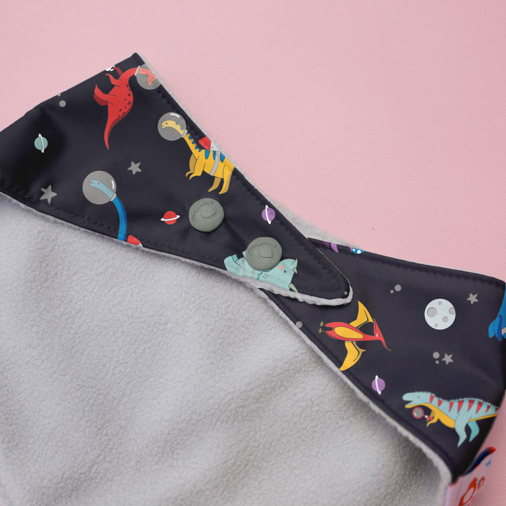 Fabric with dinosaur pattern on a pink background