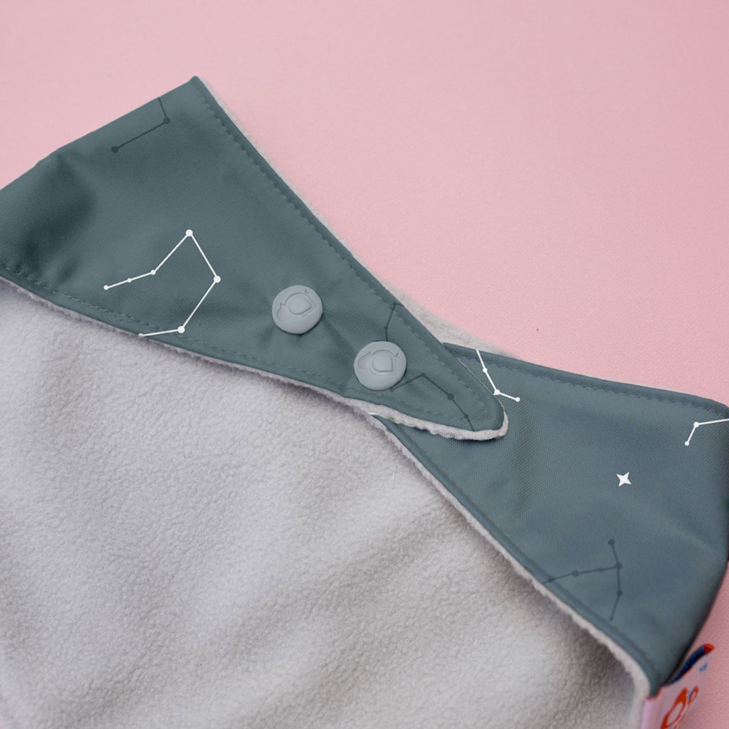 Gray and green fabric with button details on a pink background
